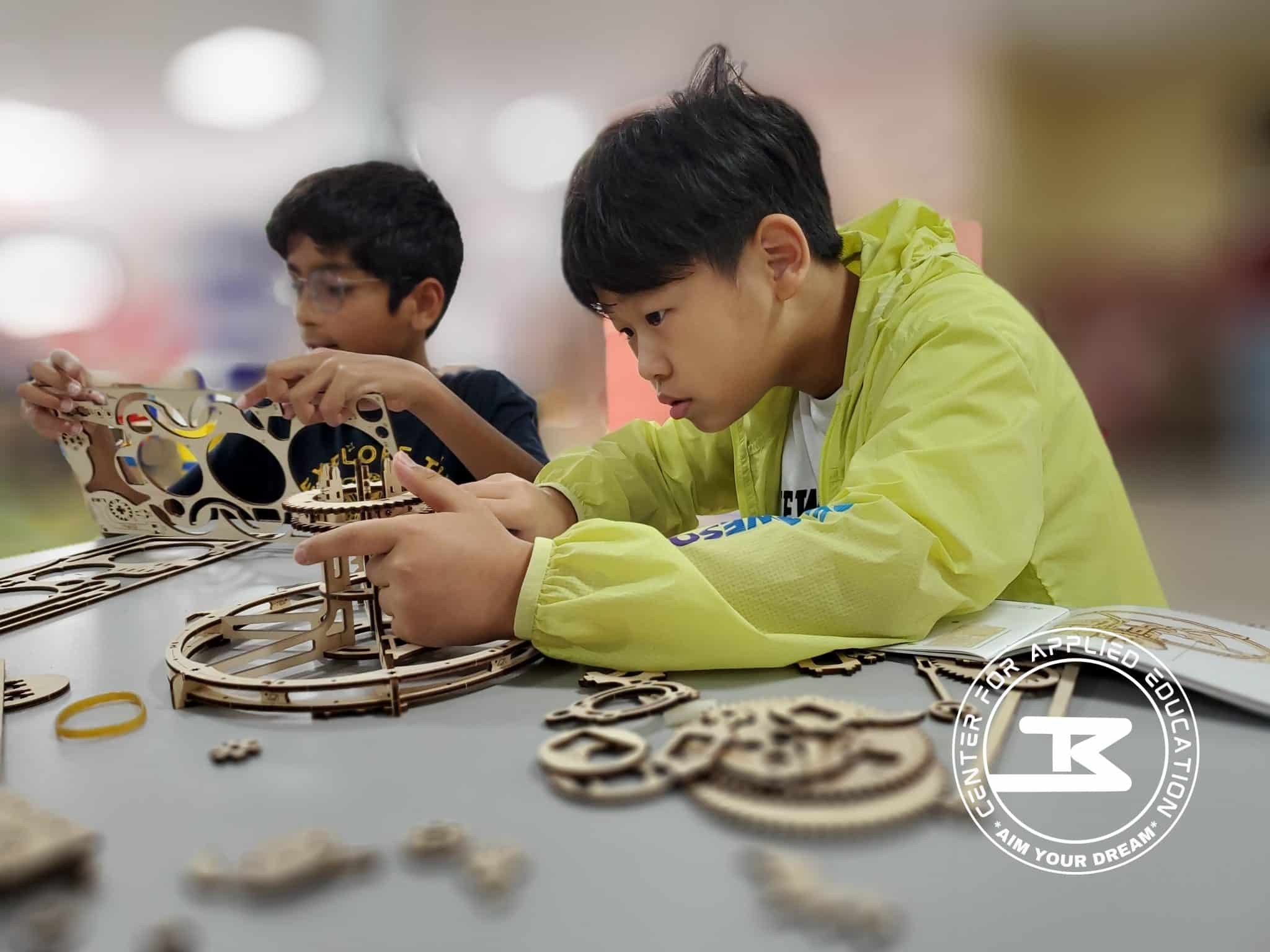 STEM Robotics fall break camp in Frisco for teens—hands-on gear assembly or 
Teen campers assembling robot gears during Fall Break STEM camp